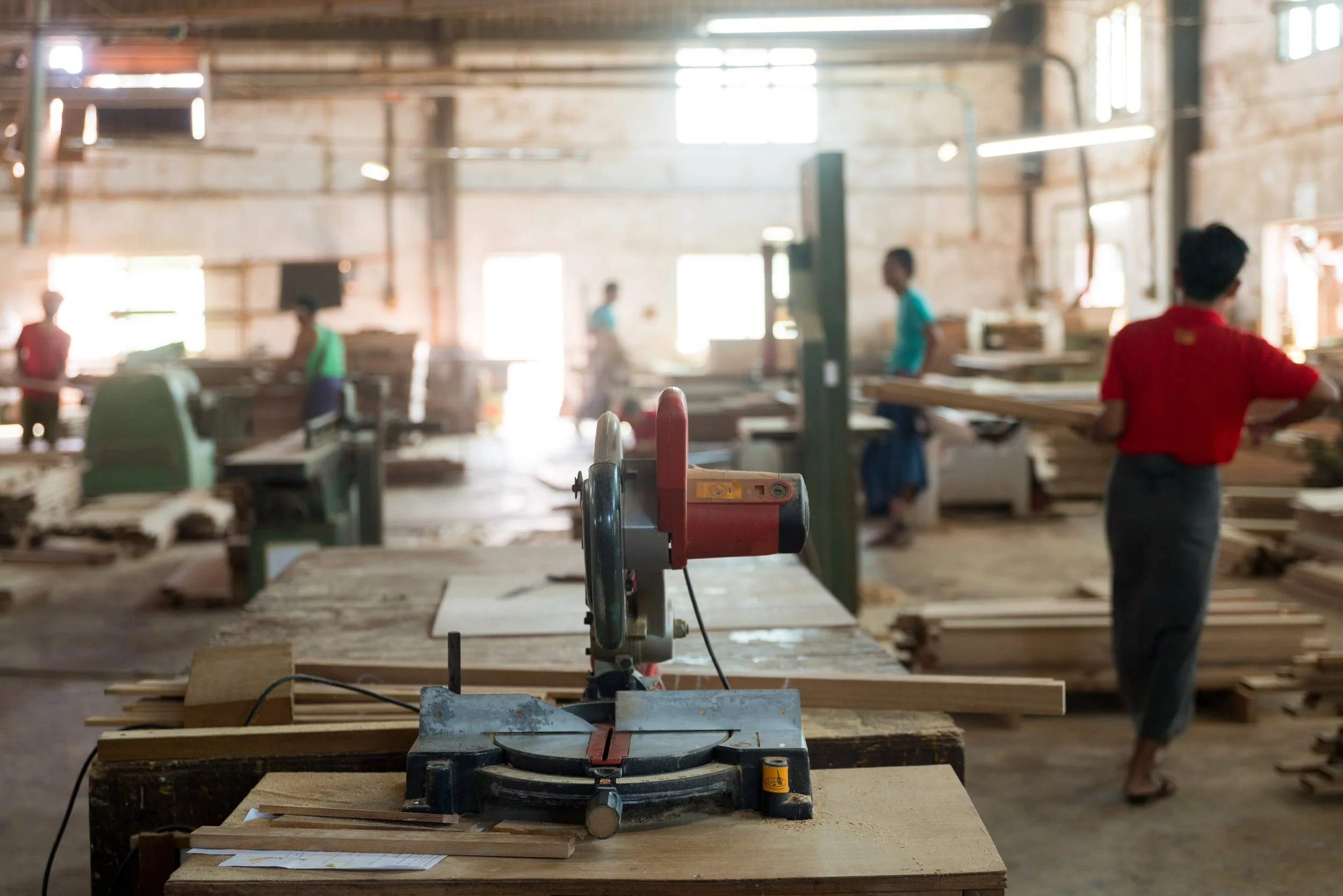 Woodworking factory floor with a saw and lumber